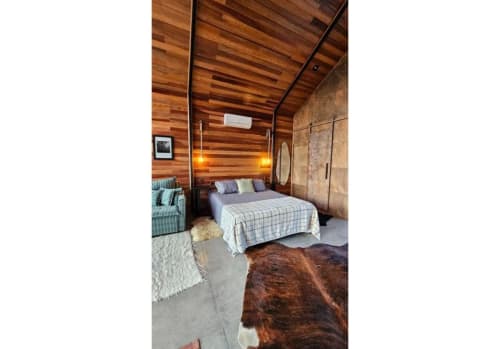 Quarto rústico estilo cabana nórdica no The Ranch Project.Co em Gonçalves, com paredes em madeira, cama aconchegante e vistas para a montanha