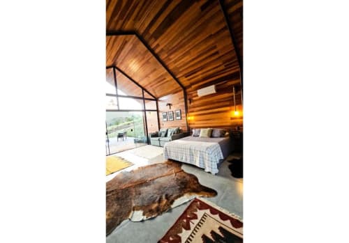 Cabana Nordic na The Ranch Project.Co em Gonçalves com interior em madeira, cama, lareira e vista para a montanha através de vidro