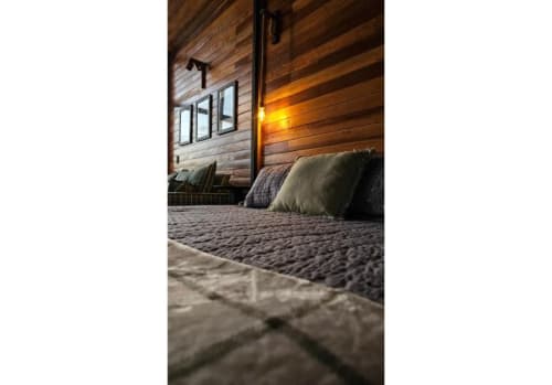 Quarto aconchegante da cabine nórdica no The Ranch Project em Gonçalves, com paredes de madeira, iluminação morna e vistas das montanhas