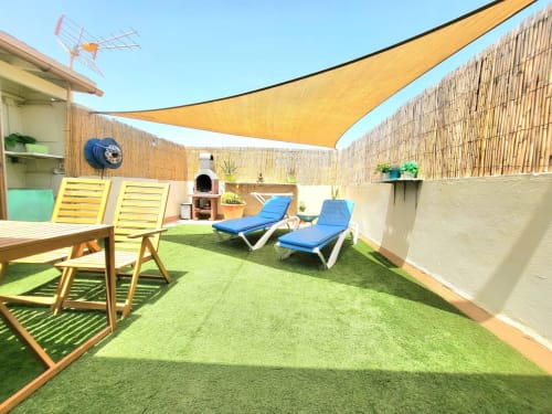 Sonnige Dachterrasse von Sara & Gino Fuerteventura mit Liegestühlen, gelbem Sonnensegel und Kunstrasen