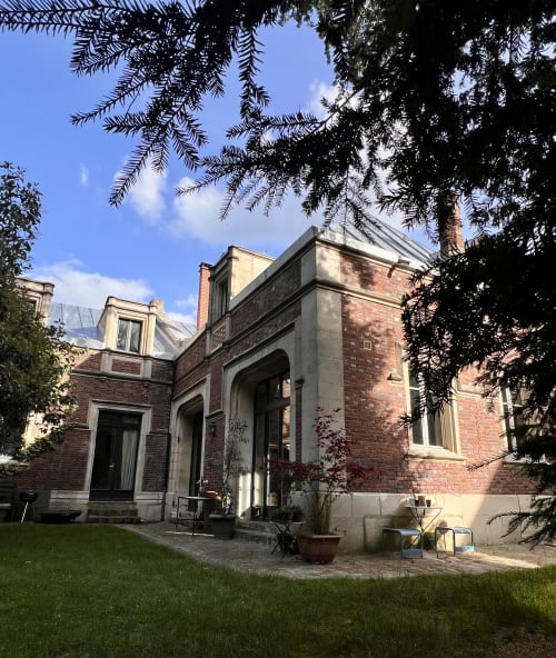 L'ancienne écurie du Château B&B à Boissy-Saint-Léger, bâtiment historique en brique avec jardin paysagé et cour