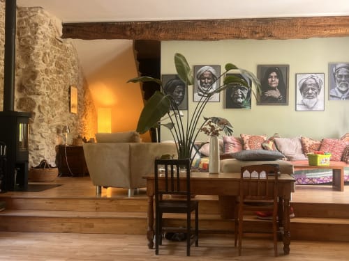 Suite rustique aux Anciennes écuries du Château avec poutres en bois, cheminée en pierre et vue sur le jardin