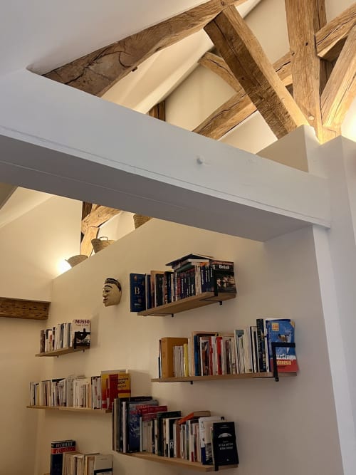 Poutres de plafond en bois et étagères de bibliothèque remplies de livres dans la chambre d'hôte du château de Boissy-Saint-Léger