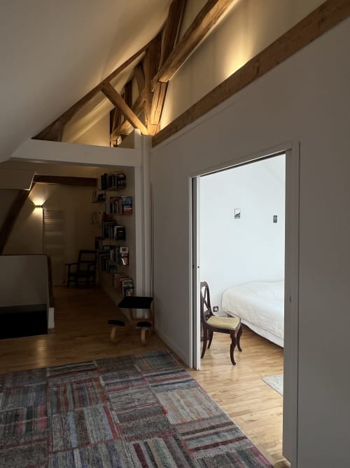 grand espace bibliothèque sur le palier donnant sur une jolie petite chambre entièrement rénové aux Anciennes Écuries du Château B&B avec séjour aux poutres apparentes, parquet et