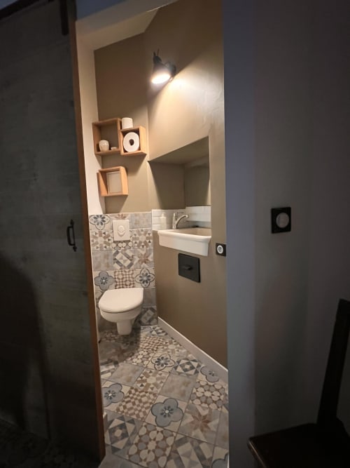 Salle de bains moderne aux Anciennes Écuries du Château B&B à Boissy-Saint-Léger avec carrelage motifs, lavabo blanc et toilettes