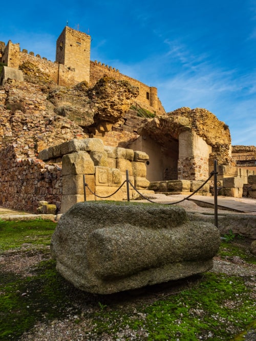 Ruinas romanas antiguas con columna de piedra y torre medieval en Villanueva de la Serena, Badajoz