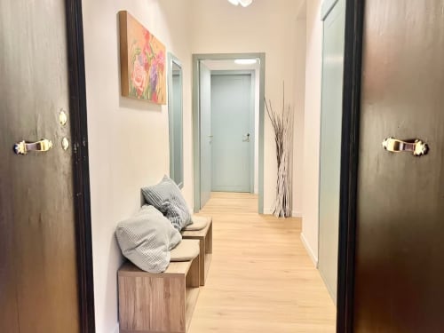 Corridoio moderno nell'appartamento di Bologna a Living Palazzi Storici con panchina in legno, illuminazione contemporanea e accesso alle camere