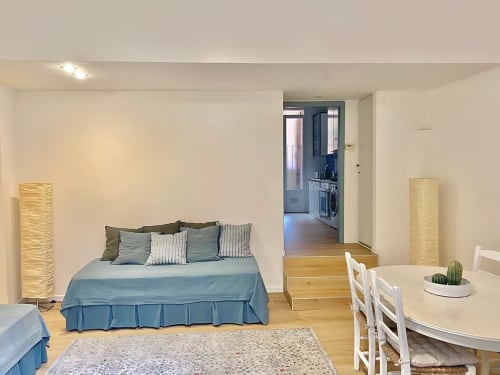 Monolocale moderno a Bologna con letto, zona pranzo, angolo cottura, pavimenti in legno e arredamento contemporaneo