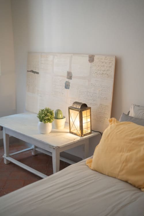 Scrivania in camera da letto con cactus in vaso, lanterna decorativa e luci d'atmosfera nell'appartamento di Bologna