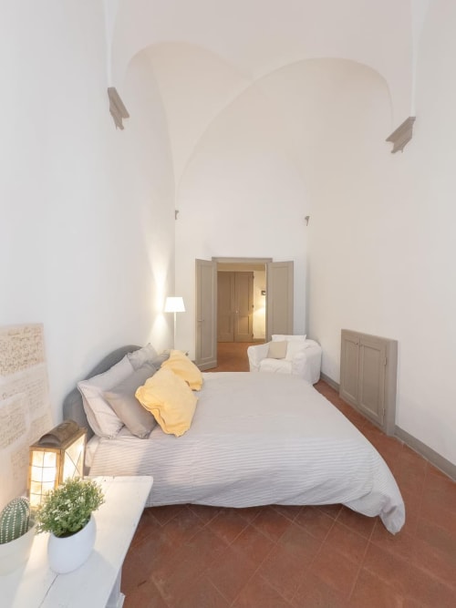 Camera luminosa dell'appartamento bolognese con letto, soffitto a volta, pavimenti in legno e servizi moderni presso Living Palazzi Storici