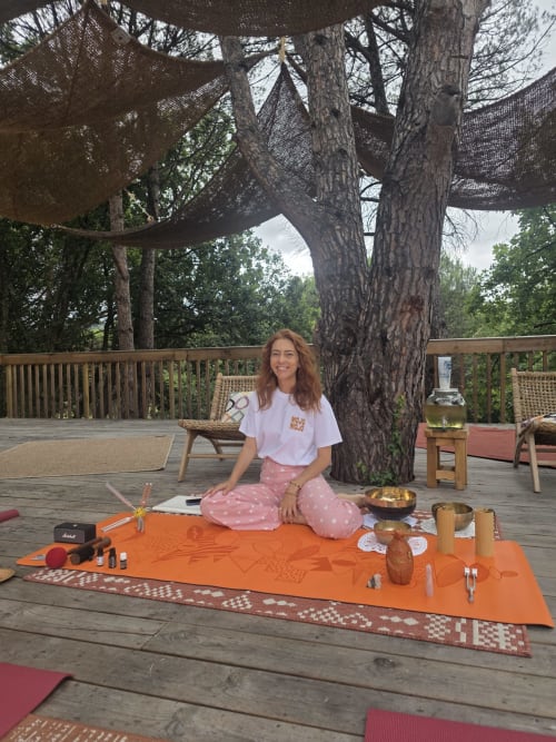 Woman meditating under large tree at Hôtel Les Lauriers wellness retreat in Saint-Tropez