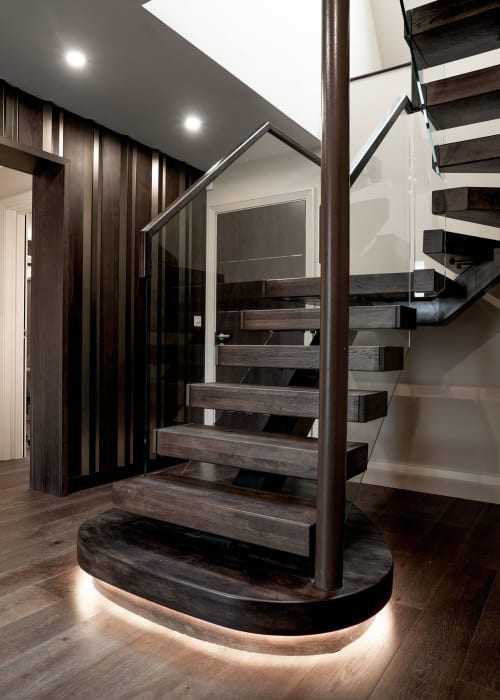 Modern spiral staircase with dark wood steps and glass railing at 100 Banbury Road Oxford boutique hotel