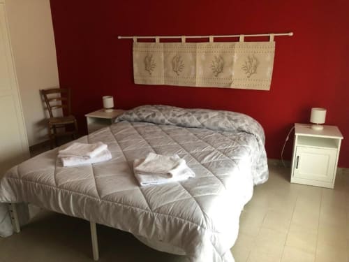 Ampia camera doppia con letti gemelli, parete rossa, vista sulla corte interna - B&B Daddanca ad Ales