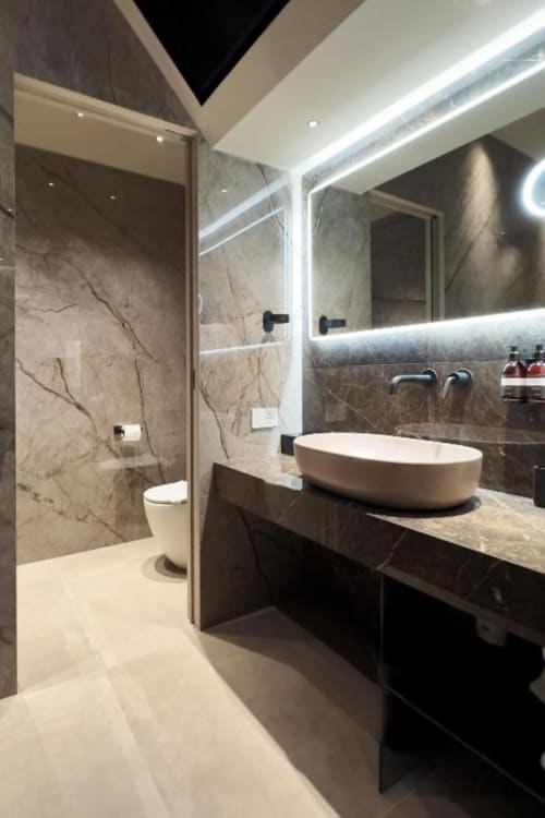 Bagno moderno presso Donna Filomena Luxury Suites con pareti in marmo, specchio illuminato, lavabo a coppa e doccia a filo