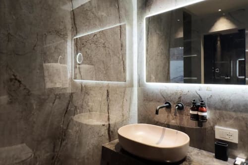 Bagno lussuoso da Donna Filomena con piastrelle in marmo, specchio LED, lavabo ovale e rubinetteria moderna a parete in stile italiano
