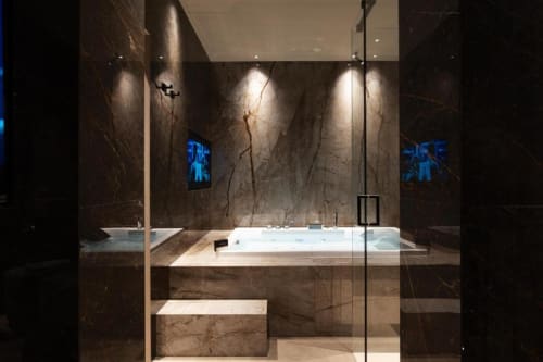Bagno lussuoso a Donna Filomena con pareti in marmo scuro, moderna vasca idromassaggio, illuminazione d'atmosfera e accenti blu