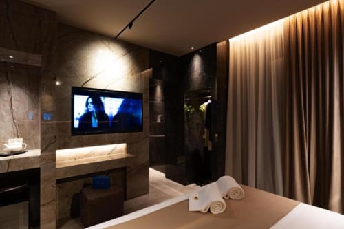 Lussuosa camera d'albergo con TV a schermo piatto, marmi pregiati, bagno moderno e tende color crema alle Donna Filomena Suites, Italia