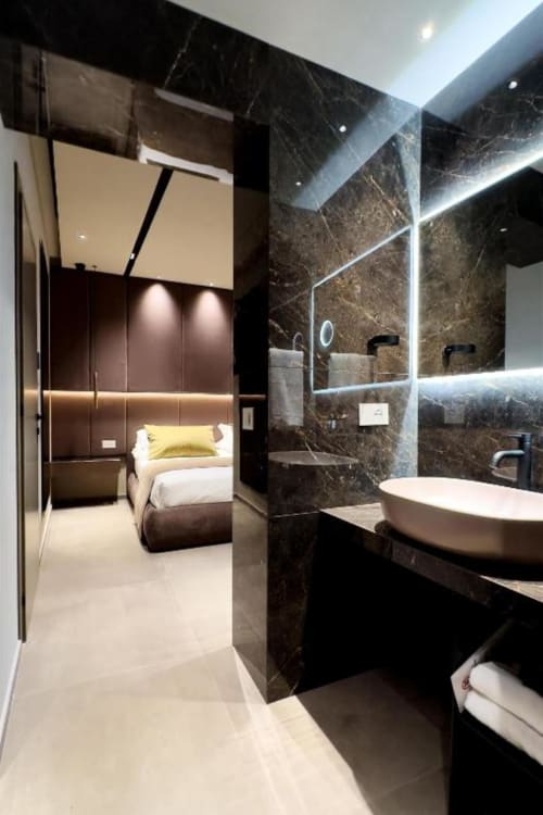Lussuoso bagno nella Superior Queen Room di Donna Filomena, Italia, con pareti in marmo, finiture moderne e vista sulla camera da letto
