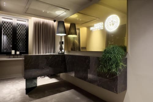 Moderna hall di lusso dell'Hotel Donna Filomena con scrivania in marmo scuro, illuminazione d'atmosfera e arredamento contemporaneo in Italia