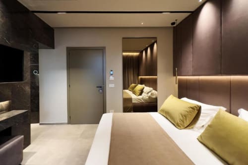 Lussuosa camera da letto a Donna Filomena con letto queen, cuscini dorati, arredamenti moderni e vista sulla corte interna in Italia