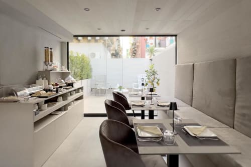 Ristorante moderno presso Donna Filomena Luxury Suites in Italia con tavoli eleganti, sedie nere e splendida vista sulla corte interna