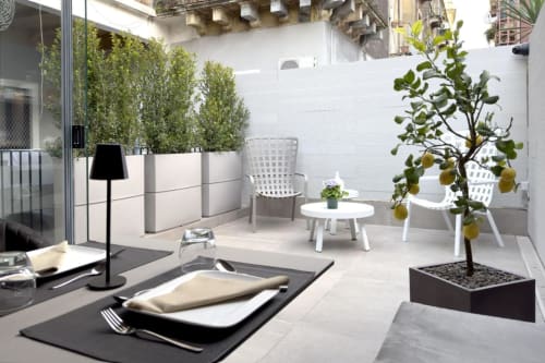 Terrazza esclusiva sul tetto di Donna Filomena Luxury Suites con zona pranzo, albero di limone, arredo bianco e piante in vaso