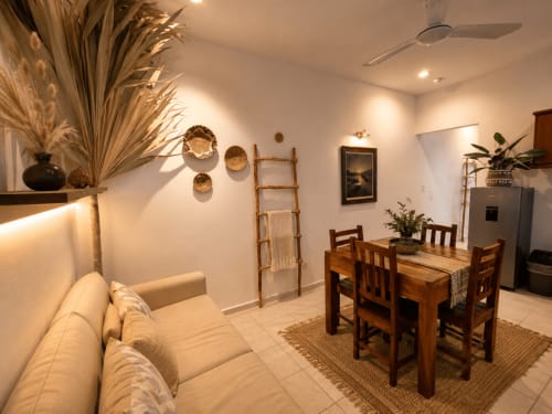 Cozy Hotel Holbox Centro studio with beige sofa, wooden dining table, and rustic décor in Holbox, Mexico