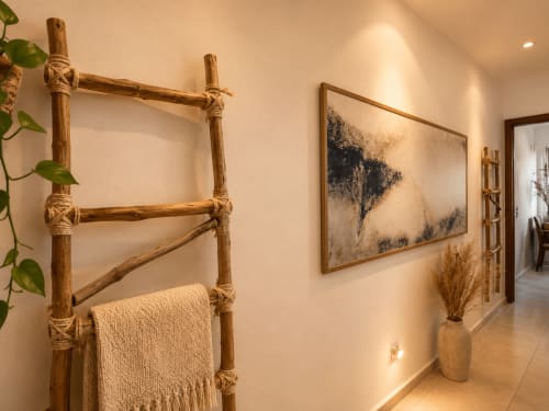 Rustic wooden ladder with rope ties and cream towel in Hotel Holbox Centro hallway with minimalist decor