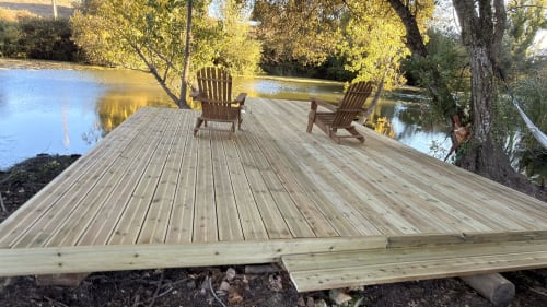 Wooden deck with Adirondack chairs overlooking serene river at Herdade Do Vidigal, Montemor-o-Novo