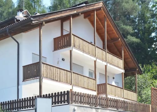 Moderno appartamento alpino con terrazza e balconi presso la casa Debby Siusi a Siusi, Italia, circondato da alberi forestali.