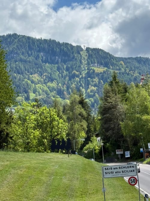 Veduta del paesaggio montano dalla casa Debby Siusi in Alto Adige, con picchi boscosi e lussureggianti prati verdi