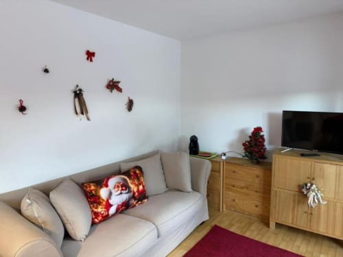 Accogliente soggiorno nella casa di Debby Siusi a Siusi con decorazioni natalizie, divano beige e vista montagna