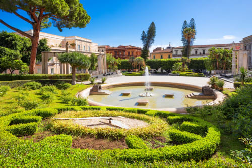 Giardino lussuoso all'italiana con fontana circolare, siepi curate e villa neoclassica presso Donna Filomena Luxury Suites