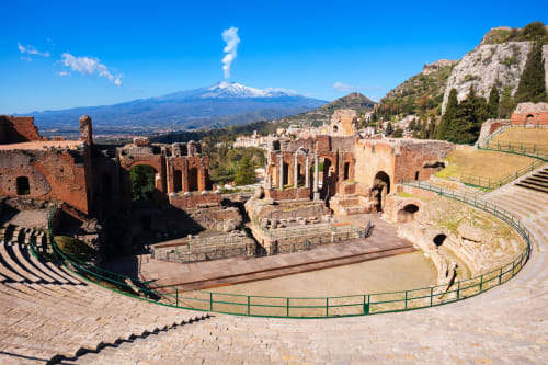 Rovine dell'antico teatro greco di Taormina, Sicilia con l'Etna fumante in lontananza