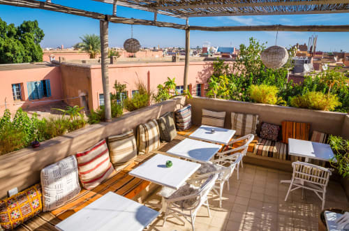Riad Casa Angelo rooftop terrace in Marrakech with seating, striped cushions, and city views