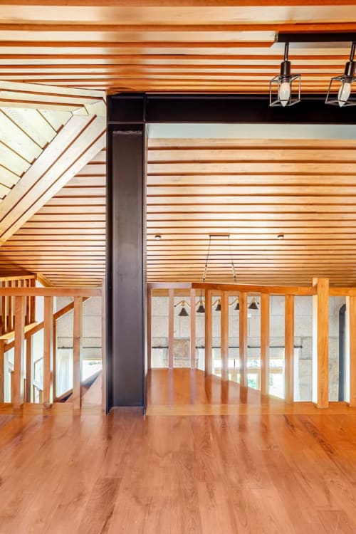 Spacious wooden loft interior at Casa dos Vasconcelos cottage in Chaves, Portugal with slated ceiling and modern amenities
