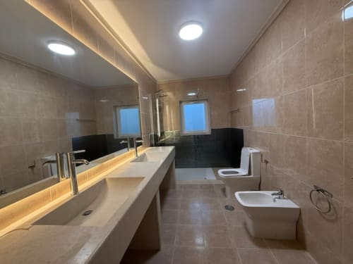 Modern bathroom at Casa dos Vasconcelos cottage in Chaves with double sink, toilet, bidet, and bathtub with ambient lighting