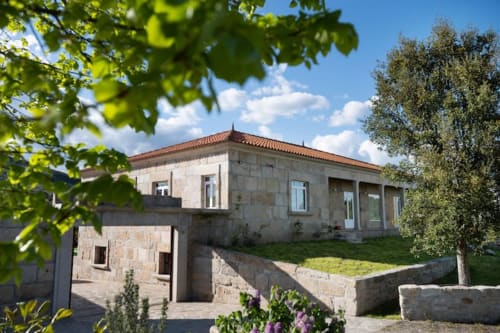 Casa dos Vasconcelos cottage in Chaves, Portugal - stone exterior with terracotta roof and manicured grounds