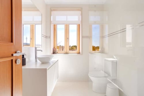 Modern bathroom in Casa dos Vasconcelos cottage, Chaves Portugal with white fixtures, wooden windows and natural light