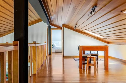 Spacious wooden cottage interior in Chaves with vaulted ceiling, dining area, and ocean view at Casa dos Vasconcelos B&B