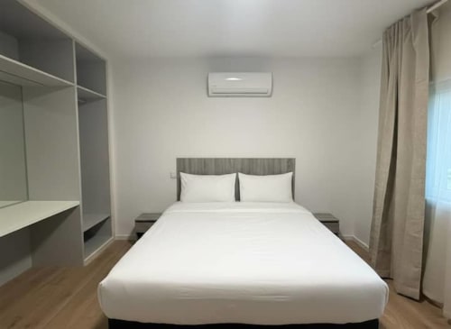 Modern bedroom at Casa dos Vasconcelos cottage in Chaves with queen bed, air conditioning, and contemporary furnishings