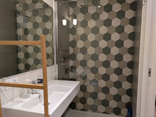Bagno moderno con parete doccia in piastrelle esagonali presso BnB del Parlamento Palermo, con lavabo bianco e specchio con cornice in legno