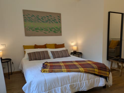 Camera moderna presso BnB del Parlamento Palermo con letto queen, cuscini rigati, plaid, opere d'arte, specchio e lampade comodino