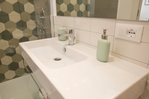 Moderno lavabo da bagno con parete doccia in piastrelle esagonali verdi presso BnB del Parlamento Palermo