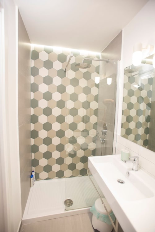 Bagno moderno con parete doccia in piastrelle esagonali presso BnB del Parlamento Palermo, con lavabo bianco e box doccia in vetro