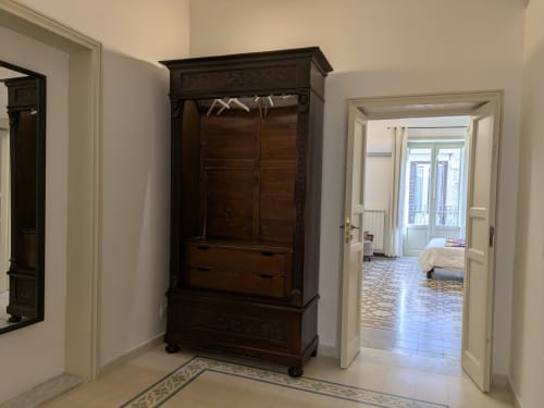 Elegante ingresso con armadio in legno scuro e porte bianche in appartamento BnB a Palermo con vista sulla città