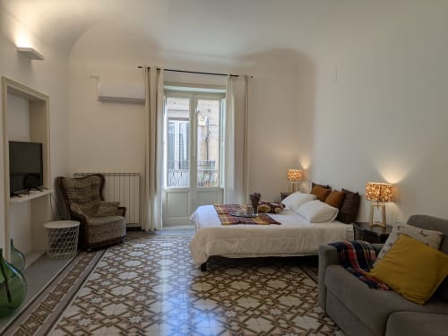 Camera da letto spaziosa con balcone presso BnB del Parlamento Palermo, con letto, area soggiorno e vista sulla città