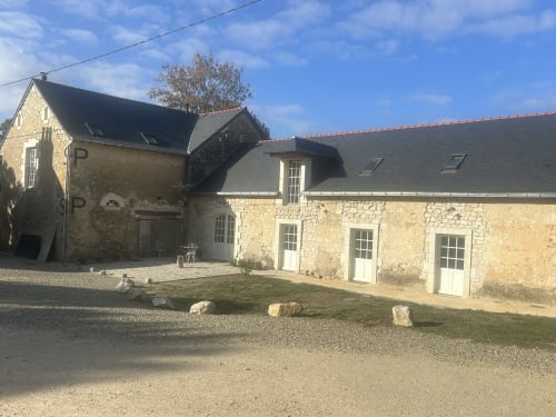 Cour pavée de la Cour Du Liège, chambres d'hôtes à Baugé-en-Anjou, avec bâtiments fermiers traditionnels et jardins soignés