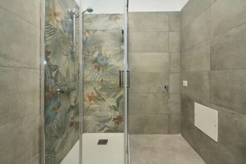 Bagno moderno con doccia a filo pavimento con piastrelle dal design tropicale nell'appartamento AirFlat a Rozzano