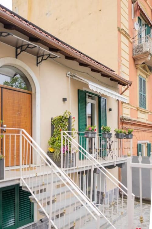 Camera doppia Luna con balcone alla La Maison Du Lion B&B a La Spezia, Italia, con persiane verdi, fiori in vaso e bianco